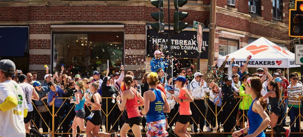 A photo of the Boston Marathon at Mile 20 in front of Heartbreak Hill Running Company